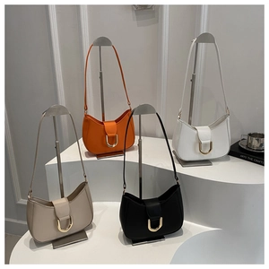Row of minimalist half-moon bags in beige, orange, white, and black with gold buckles