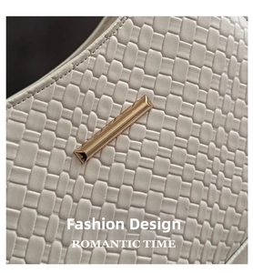 Close-up of woven cream leather underarm bag featuring a minimalist gold metal buckle