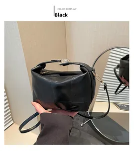 Detail view of black patchwork texture on women shoulder bag with gold hardware