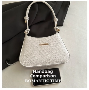 Detail view of woven leather handbag featuring knot handles and gold hardware details