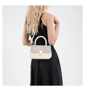 Detail of beige crossbody bag featuring shimmering silver glitter flap and gold twist lock