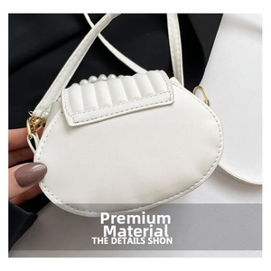 Détail du sac coquille blanc matelassé avec poignée en perles et chaîne dorée