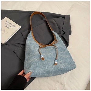 Nahaufnahme der hellblauen Stofftasche mit braunem Lederbesatz und Schleifendetail