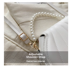 Détail du sac coquillage blanc avec chaîne en perles et fermoirs métalliques dorés réglables