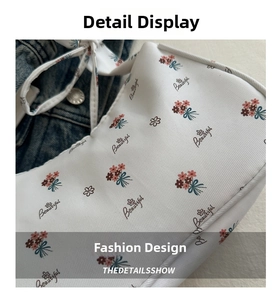 Nahaufnahme der weißen Umhängetasche mit Blumenmuster, Twill-Struktur und Textdetail