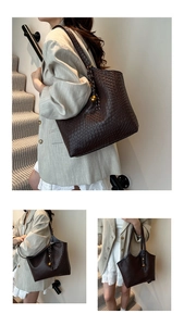 Gros plan du sac cabas marron foncé avec texture tressée et breloque dorée sphérique