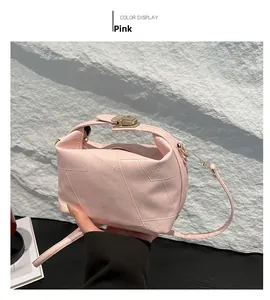 Pink pebbled leather shoulder bag with wide handle and golden metal twist lock detail