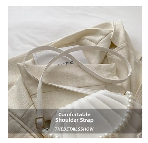 Détail du sac en cuir matelassé blanc avec poignée en perles et boucle dorée