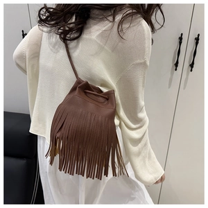 Détail d'un sac seau marron foncé avec de longues franges et cordon de serrage