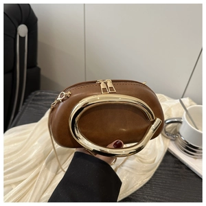 Dettaglio borsa in pelle marrone con ampio manico ovale dorato e doppia cerniera lampo