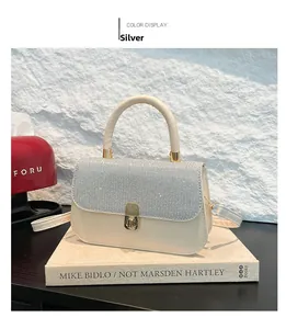 Detail of silver sequined flap on cream shoulder bag with golden metallic twist lock