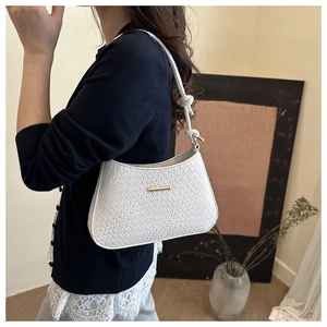 Detail of white woven PU leather underarm bag with gold buckle and knotted shoulder strap