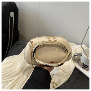 Dettaglio borsa a tracolla beige a mezzaluna con manico ad anello dorato e catena