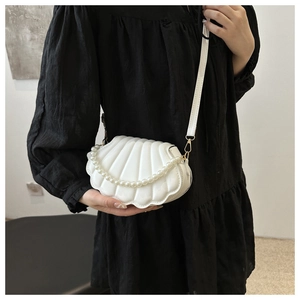 Vue détaillée du sac à bandoulière blanc en forme de coquille avec perles et texture côtelée