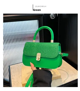 Detail of green sequined handbag with gold twist lock and rounded top handle