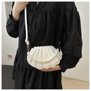 Détail du sac blanc en forme de coquillage avec texture matelassée et perles chic