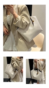 Détail du sac cabas blanc tissé avec un pendentif sphérique doré et des poignées