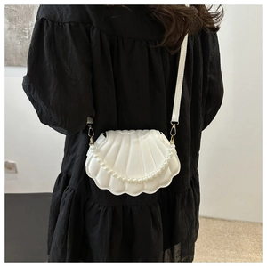 Détail du sac bandoulière blanc en forme de coquillage avec bandoulière perle