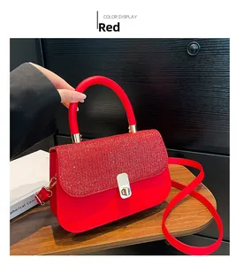 Detail view of red glitter flap with metal rotary lock on large crossbody bag