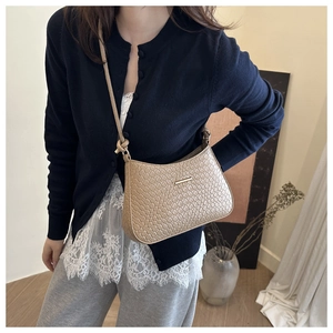 Detail of khaki woven leather shoulder bag featuring gold buckle and knotted strap