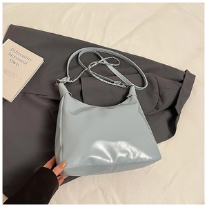 Detail of light blue hobo bag showing faux leather texture and silver chain strap