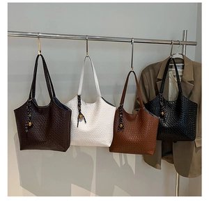 Detail of woven tote bags in four colors with decorative metal ball tassel charms