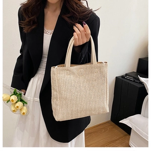 Close-up of V-shaped woven straw tote bag texture with elegant leather handles
