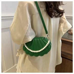 Détail du sac coquillage vert émeraude avec chaîne perlée et texture plissée