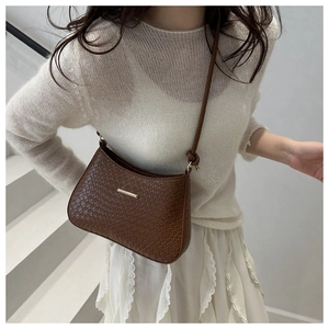 Brown crocodile embossed shoulder bag with gold metal detail on white steps