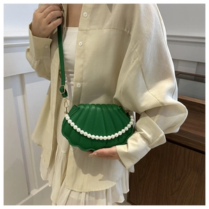 Sac bandoulière vert en forme de coquillage avec perles et texture plissée sur modèle