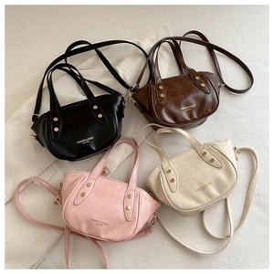 Detail of four fashionable leather bucket bags with metal studs and detachable straps