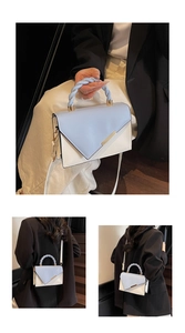 Détail du sac bandoulière bleu et beige avec poignée tressée et finitions métalliques dorées