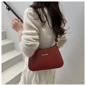 Detail view of burgundy quilted faux leather bag with elegant gold metal accent