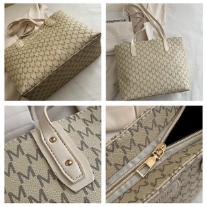 Detailed macro view of large tote bag with brown M patterns and gold zipper hardware