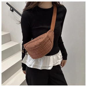 Détail du sac banane en tweed à carreaux marron avec bandoulière porté par un mannequin