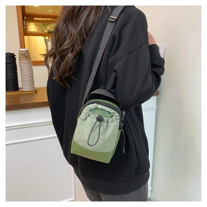 Close-up of lightweight waterproof crossbody phone bag with drawstring in green tones