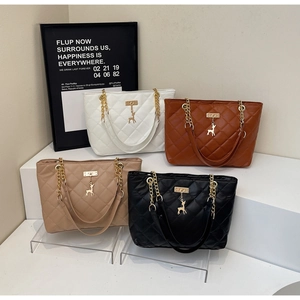 Close-up of quilted chain tote bags in four colors with iconic gold deer pendant details