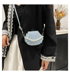 Détail du sac bandoulière bleu en forme de coquillage avec chaîne en perles