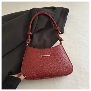 Close-up of deep red crocodile texture underarm bag with elegant gold metal accent