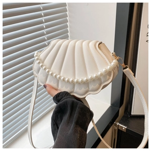 Détail du sac bandoulière blanc en forme de coquillage avec texture matelassée et perles