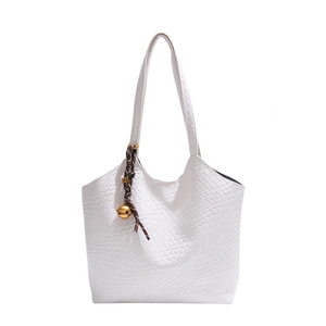 White woven leather tote bag with a golden ball charm accessory for women's daily commute