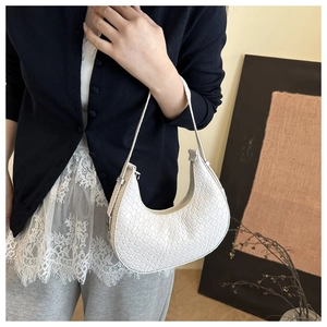 Detail of white woven texture on a minimalist hobo bag with elegant silver buckle