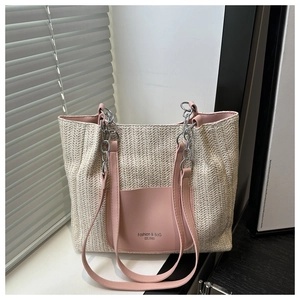 Dettaglio della borsa tote beige intrecciata con tasca in pelle rosa e catena