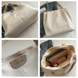 Detail view of large nylon tote bag with leather strap and fashion logo engraving