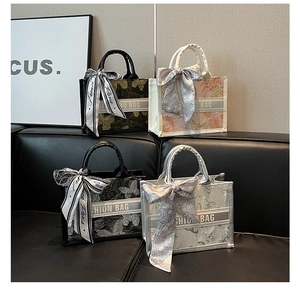 Close-up of assorted embroidered tote bags with silk ribbon bows on a leather sofa