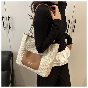 Detaillierte Nahaufnahme der Stroh-Tragetasche mit Ledertasche und Metallkettenriemen