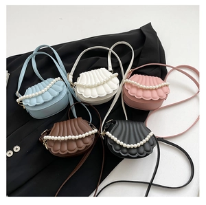 Détail de sacs à bandoulière en forme de coquille avec texture matelassée et chaîne en perles
