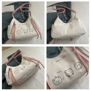 Detail of white tote bag featuring cartoon animal prints and pink shoulder strap contrast