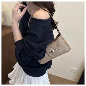 Detail of tan crocodile texture shoulder bag with star buckle and shoulder strap