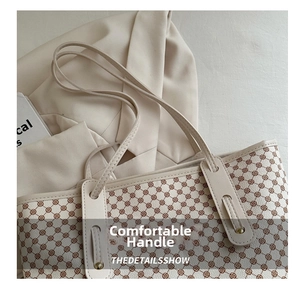 Détail du sac cabas beige à motif trèfle marron et fines lanières en cuir souple